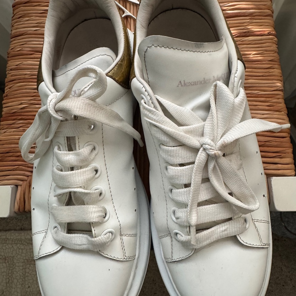 Alexander McQueen athletic shoes in white and gold.